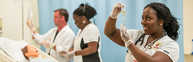 A nursing instructor at Jersey College demonstrates pediatric care to a class of nursing students.